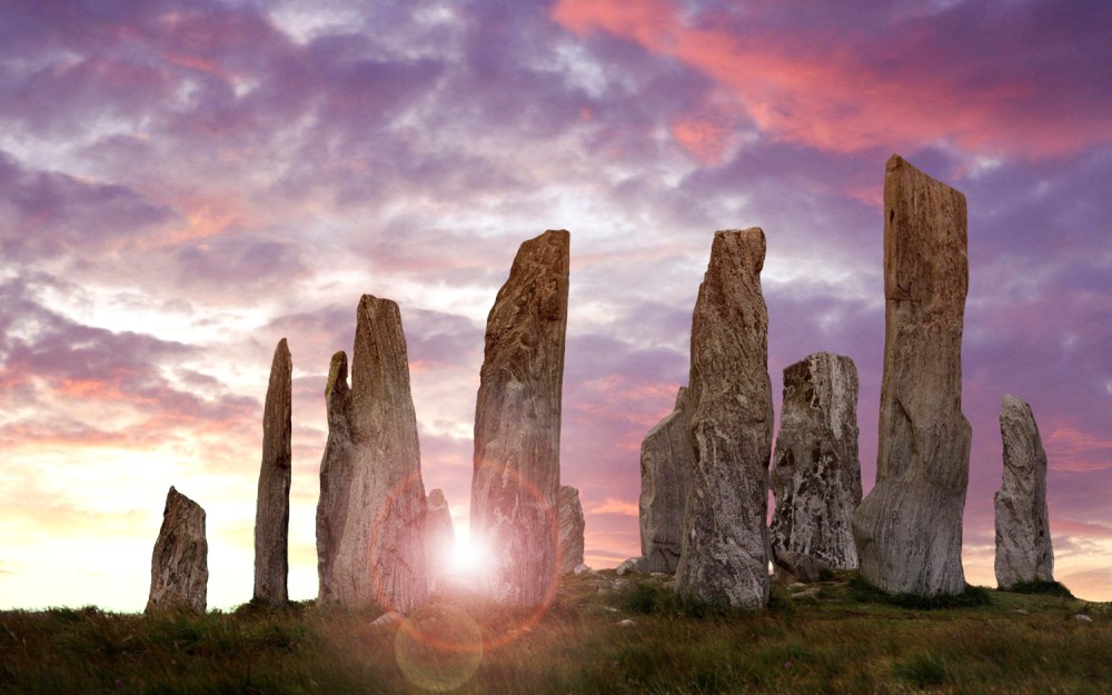 Stone monoliths under a vibrant pink and purple sky at sunset.